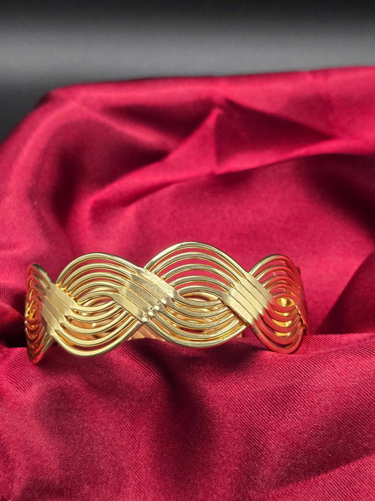 Braid Cuff Bangle in Gold finish on a neutral background