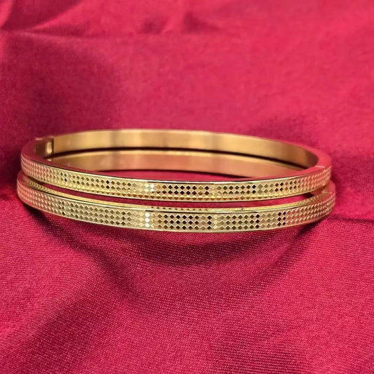 Chess Bangle in Gold finish on a neutral background