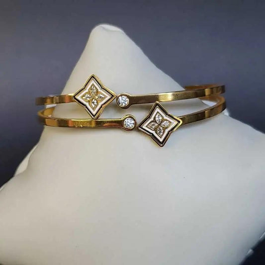Artisanal Monogram Flower Bangles in Gold finish, with cubic zirconia stone on a neutral background