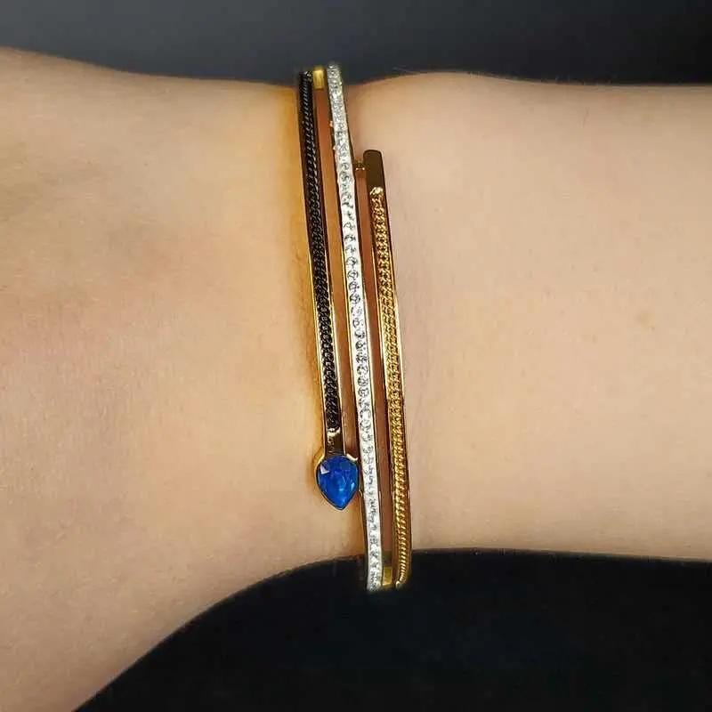 Classic Blue Teardrop Stone Bangle in Gold and Silver finish, with cubic zirconia stone on a neutral background