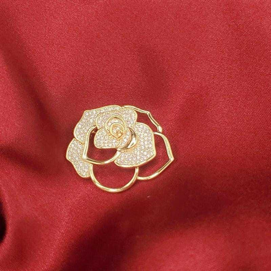 Ethereal Flower Brooch in Gold finish, with cubic zirconia stone on stones on red fabric