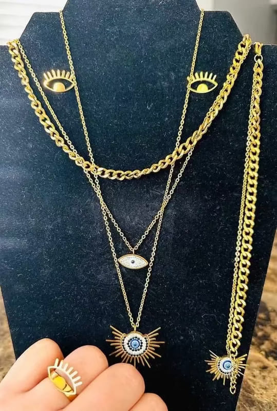 Evil Eye Set in Gold finish, with cubic zirconia stone on and enamel details, featuring layered chains and a matching ring