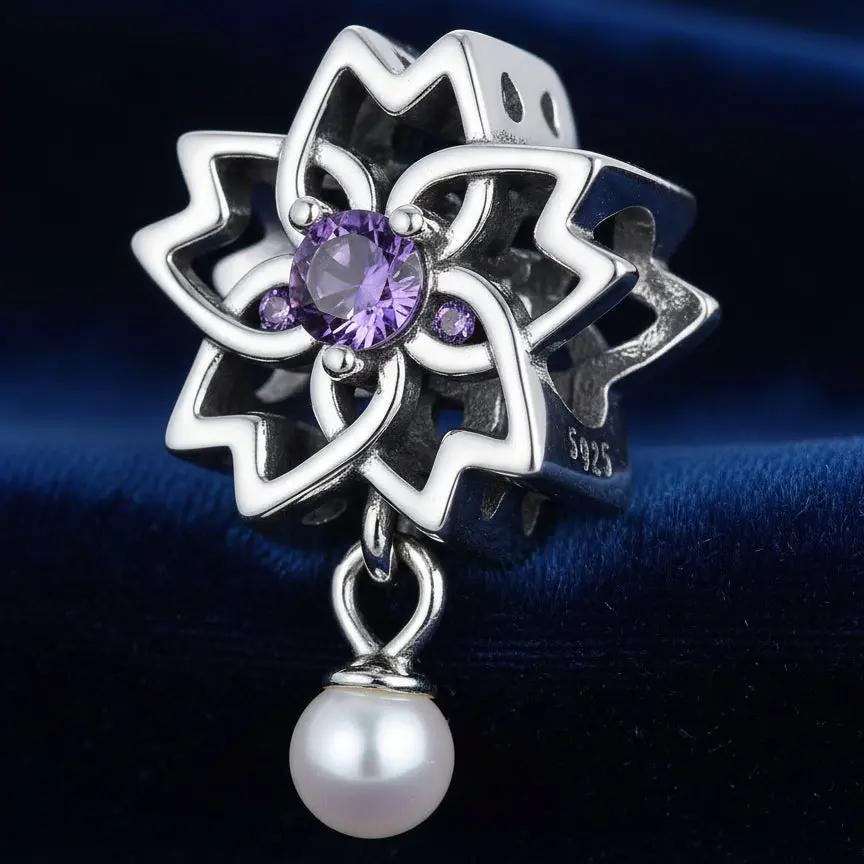 Silver pendant with purple gemstone and pearl on a dark background