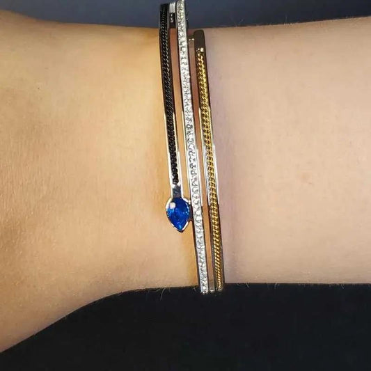 Modern Blue Teardrop Stone Bangle in Gold and Silver finish, with cubic zirconia stone on a neutral background