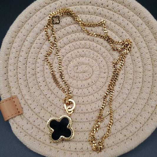 Modern Clover Necklace in Gold finish, with pearl stone on a neutral background