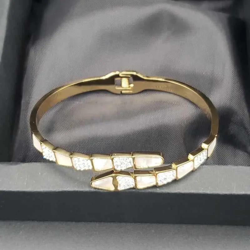 Modern Snake Bangle in Gold finish, with cubic zirconia stone on stones and white enamel detail