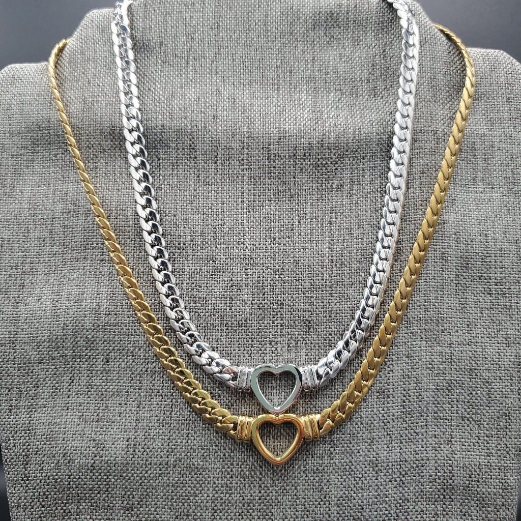 Two chain necklaces with heart pendants on a gray fabric background
