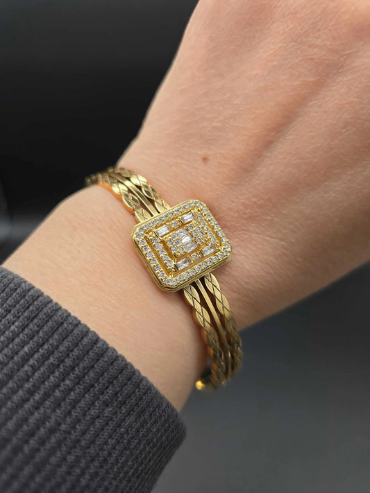 Square Diamond Twist Bangle in Gold finish, with cubic zirconia stone on a neutral background