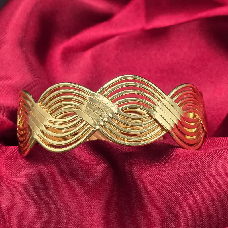 Braid Cuff Bangle in Gold finish on a neutral background