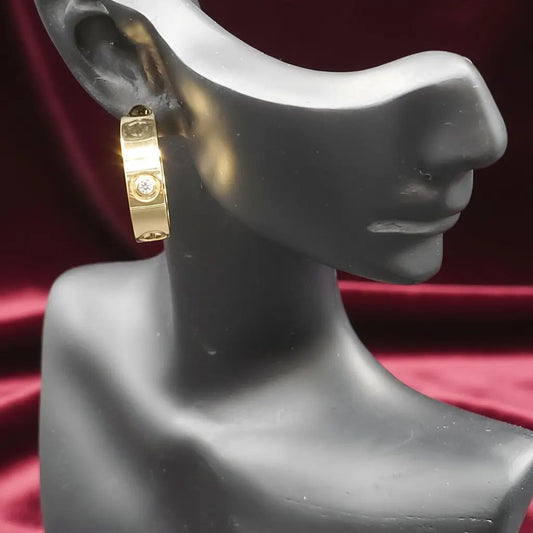 Golden C*artierc hoop Earrings on a mannequin ear