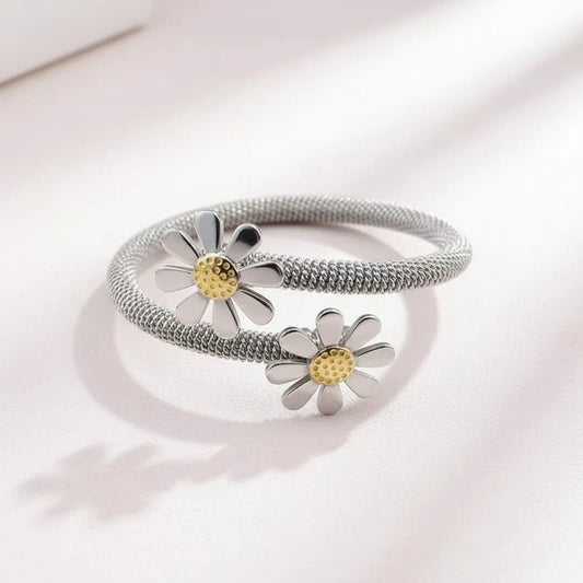 Silver bracelet with daisy flower charms on a white background