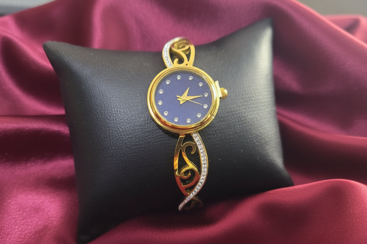 Gold watch on a black cushion with a red fabric background