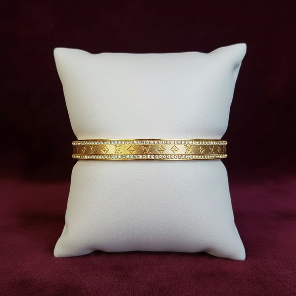 Gold and diamond bracelet on a white mannequin arm against a black background