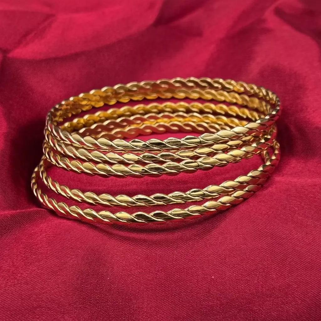 Golden twisted bangle on a red fabric background