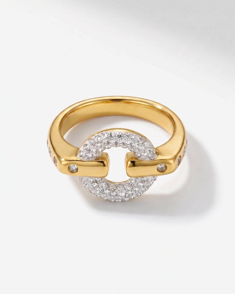 A gold ring featuring a circular pavé diamond center with two curved gold bars extending outwards, each adorned with small accent diamonds, shown on a light gray background.