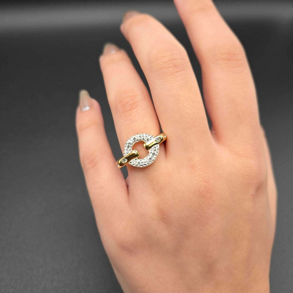 Gold and silver ring on a hand against a dark background