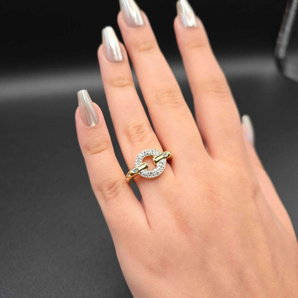 Hand wearing a gold and diamond ring on a dark background