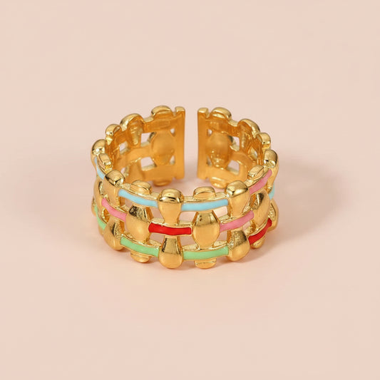 A gold-plated open band ring featuring interwoven horizontal bands of pink, red, light blue, and mint green enamel.