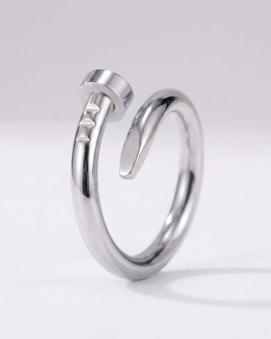 A polished silver-toned metal ring with a unique open design resembling a stylized hammer, photographed on a clean light gray background.