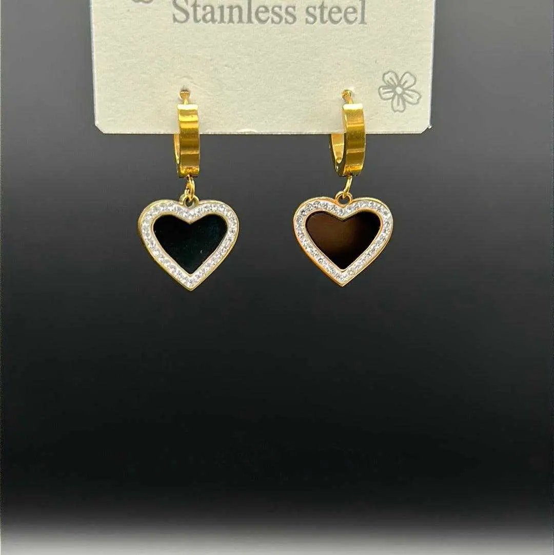 Artisanal Heart Earrings in Gold finish, with cubic zirconia stone on a neutral background