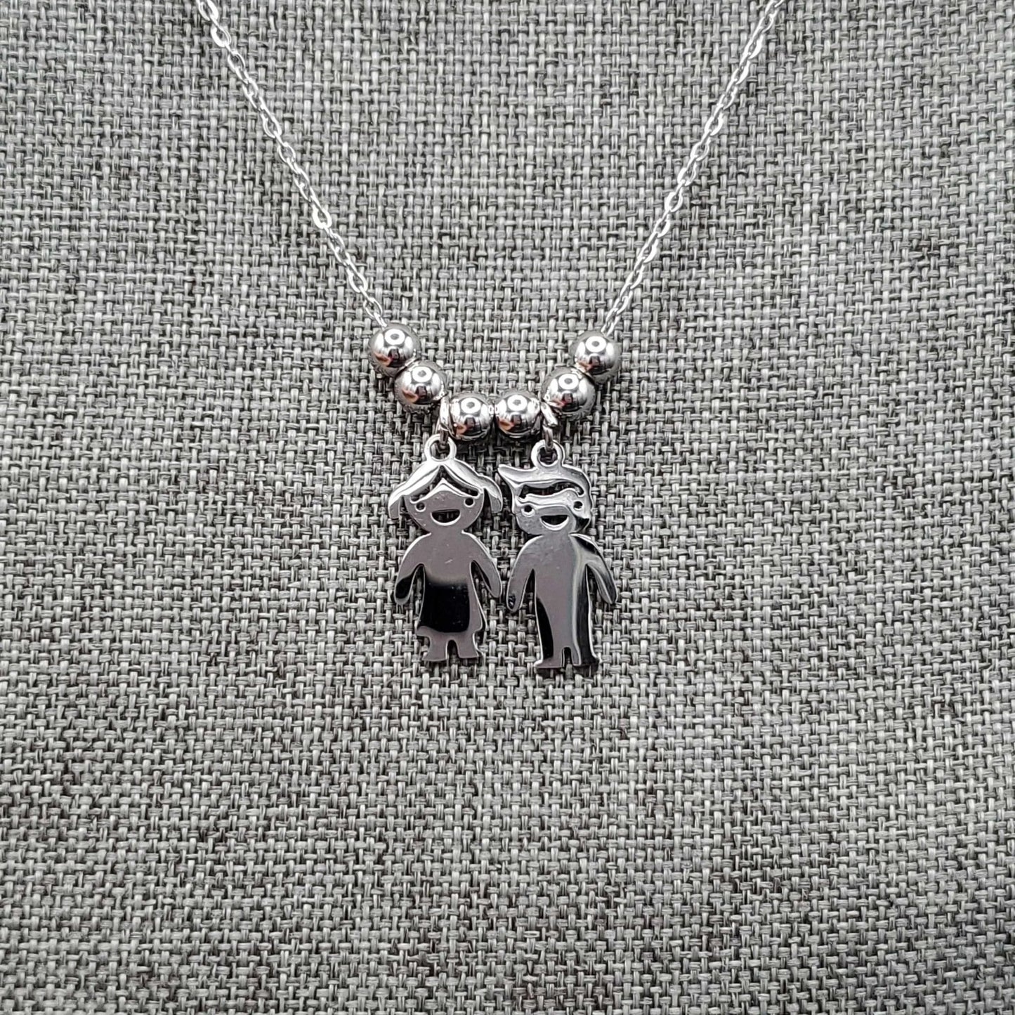 Boy & Girl Necklace in Gold finish on a neutral background
