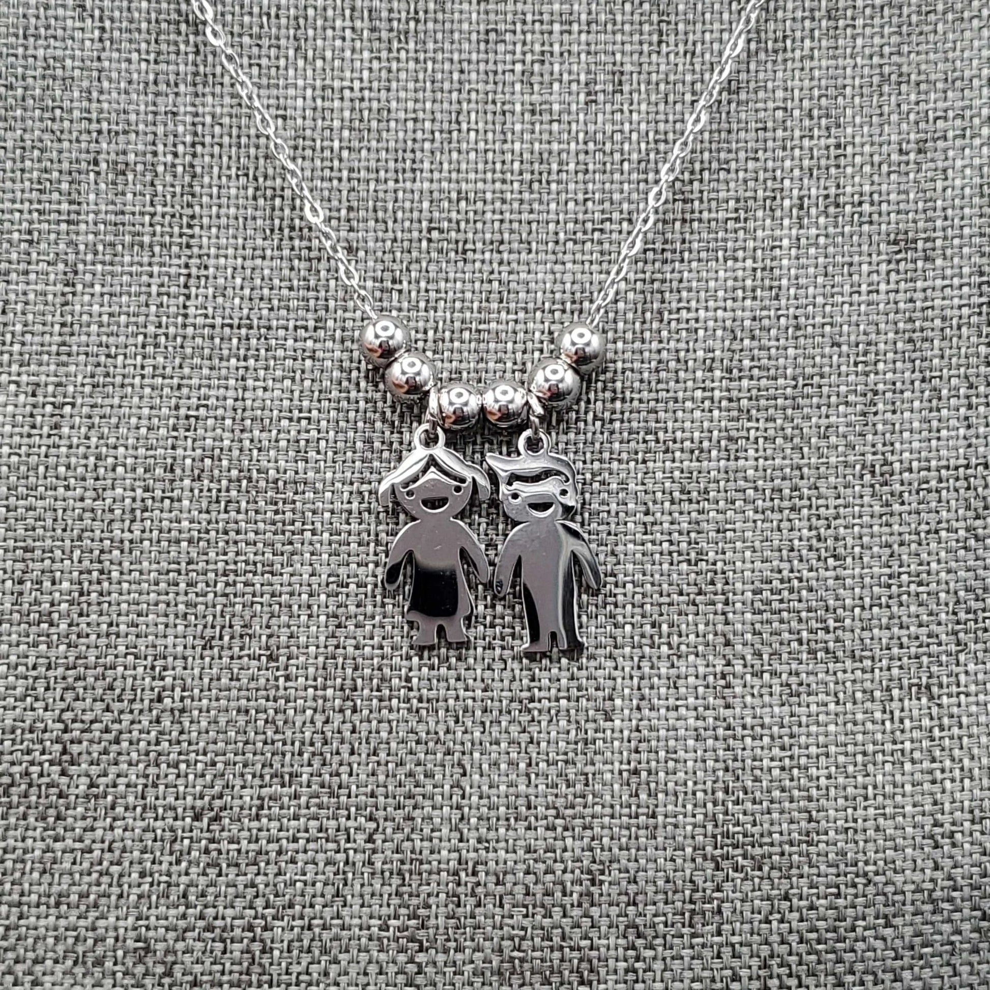 Boy & Girl Necklace in Gold finish on a neutral background