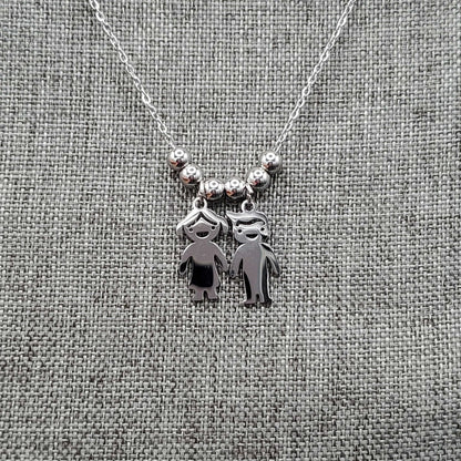 Boy & Girl Necklace in Gold finish on a neutral background