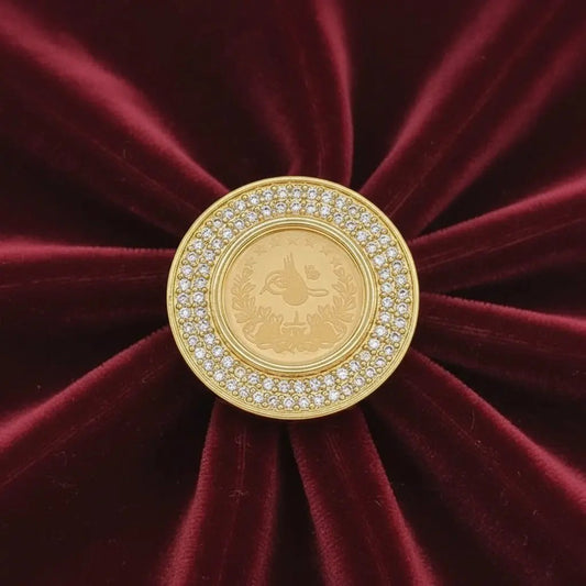 Classic Lira Coin Ring in Gold finish, with cubic zirconia stone on stones on a red velvet background
