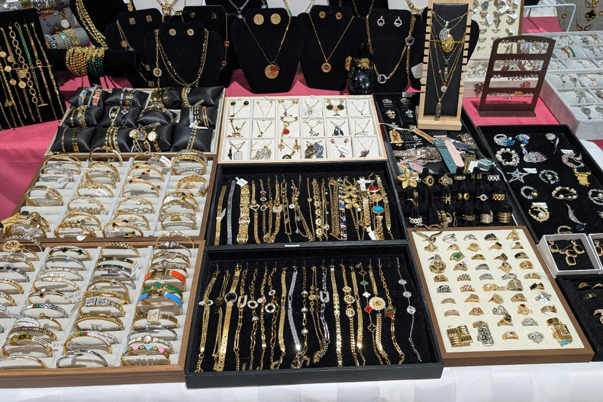 Jewelry display with various necklaces, bracelets, and earrings on a table.