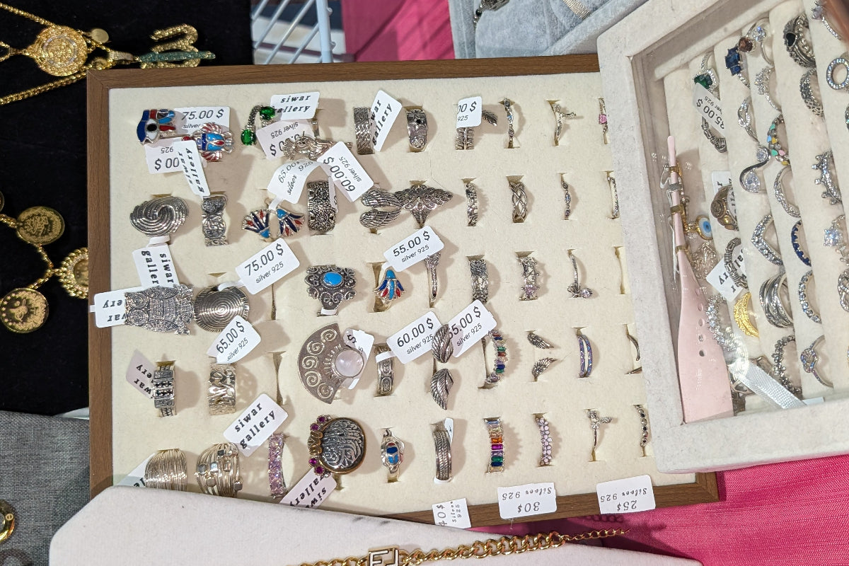 display of collection of sterling silver rings on a wooden frame