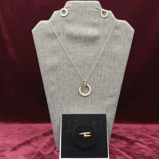 Gold necklace with a pendant on a gray fabric stand against a black background