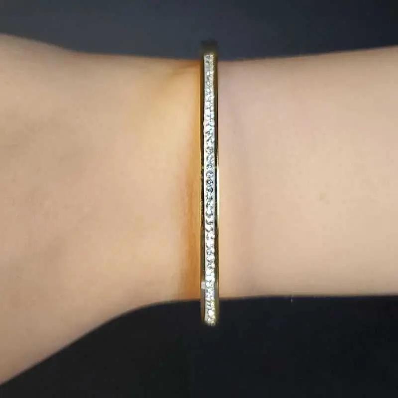 Exquisite Lovely Bangle in Gold finish, with cubic zirconia stone on stones on a woman's wrist