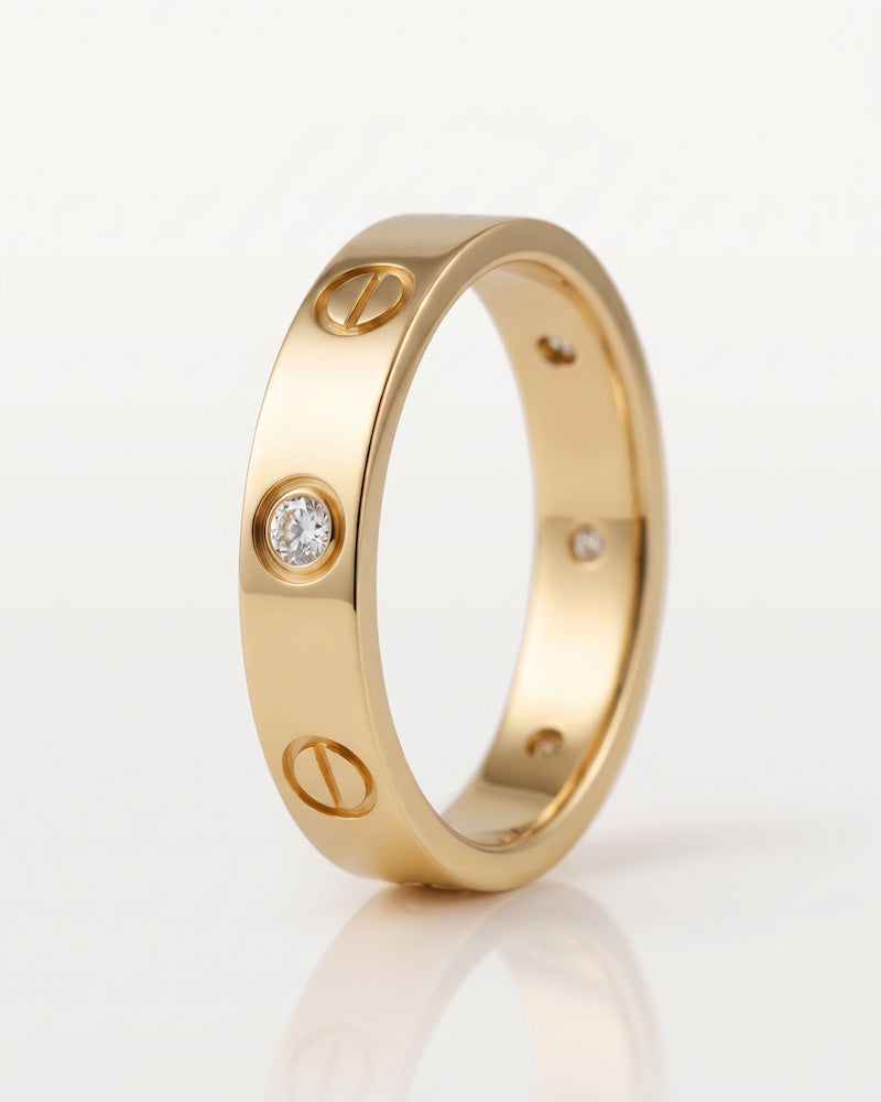 A rose gold ring with a screw motif and small clear gemstones, photographed on a clean white background.