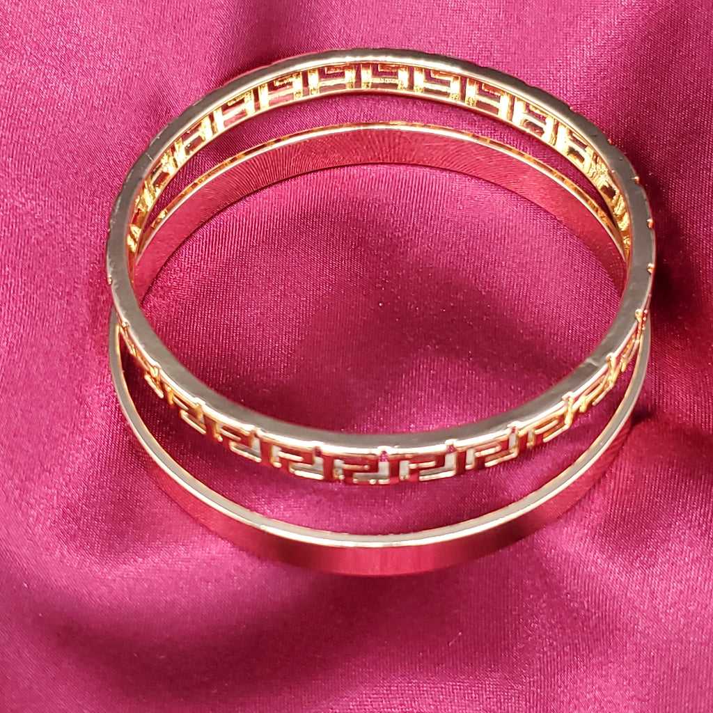 Modern Greek Key Bangle in Gold finish on a neutral background