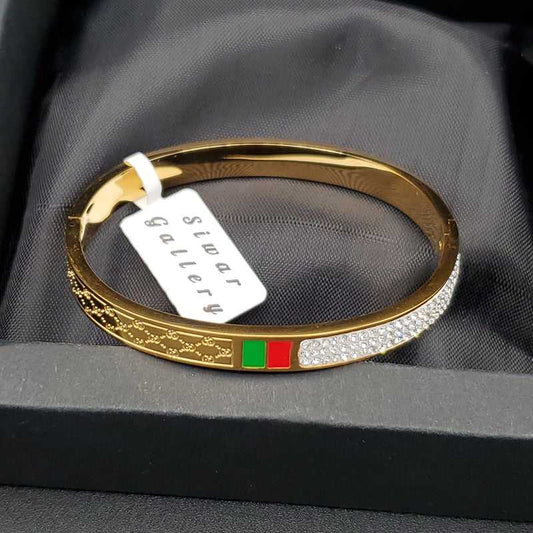 Modern Signature Bangle in Gold finish, with cubic zirconia stone on stones and red and green enamel accents