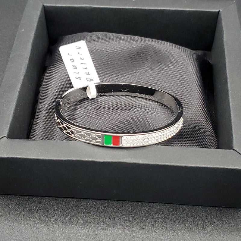 Modern Signature Bangle in Gold finish, with cubic zirconia stone on stones and red and green enamel stripe