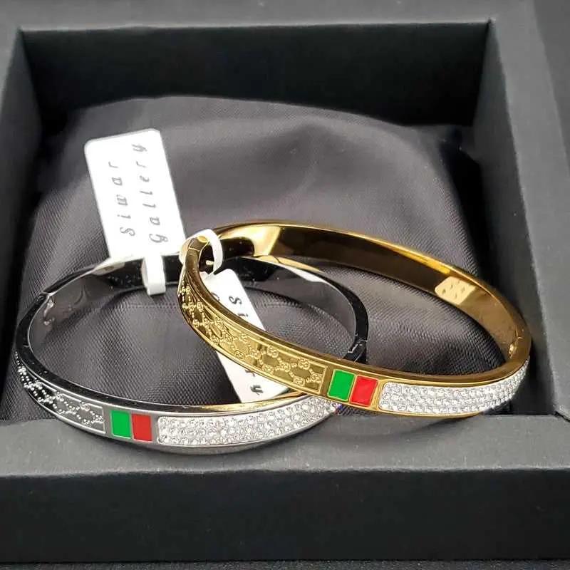 Modern Signature Bangle in Gold finish, with cubic zirconia stone on stones and red and green enamel bands