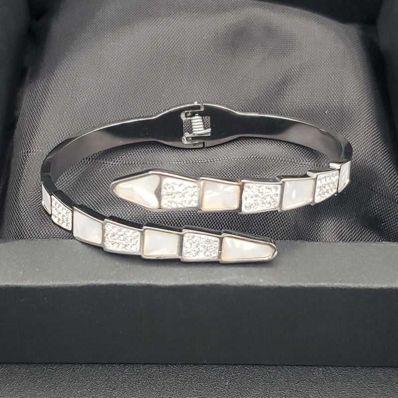 Modern Snake Bangle in Gold finish, with cubic zirconia stone on a neutral background