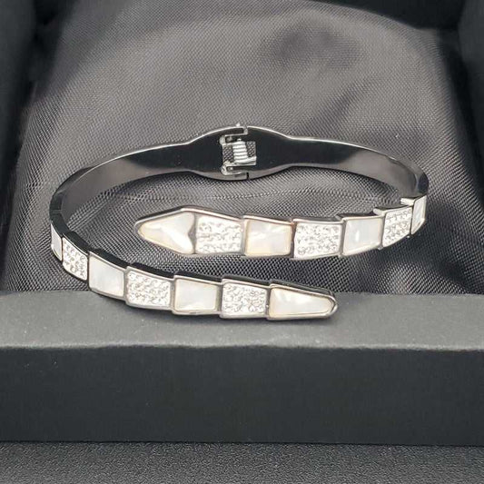 Modern Snake Bangle in Gold finish, with cubic zirconia stone on a neutral background