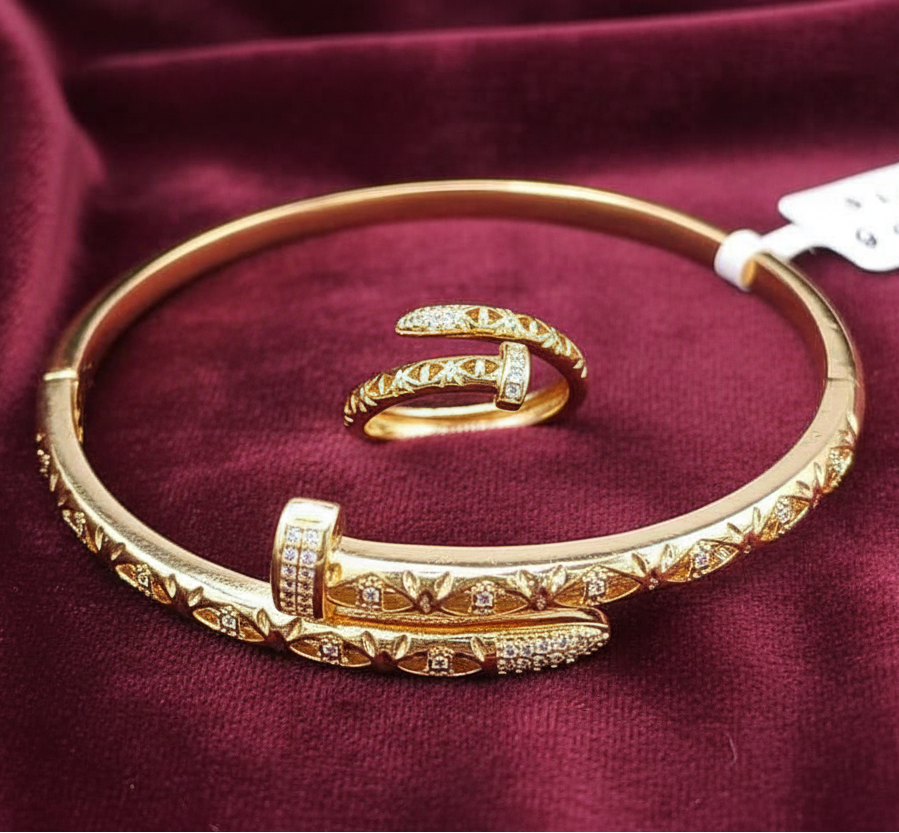 Gold bangle and ring set on a burgundy fabric background