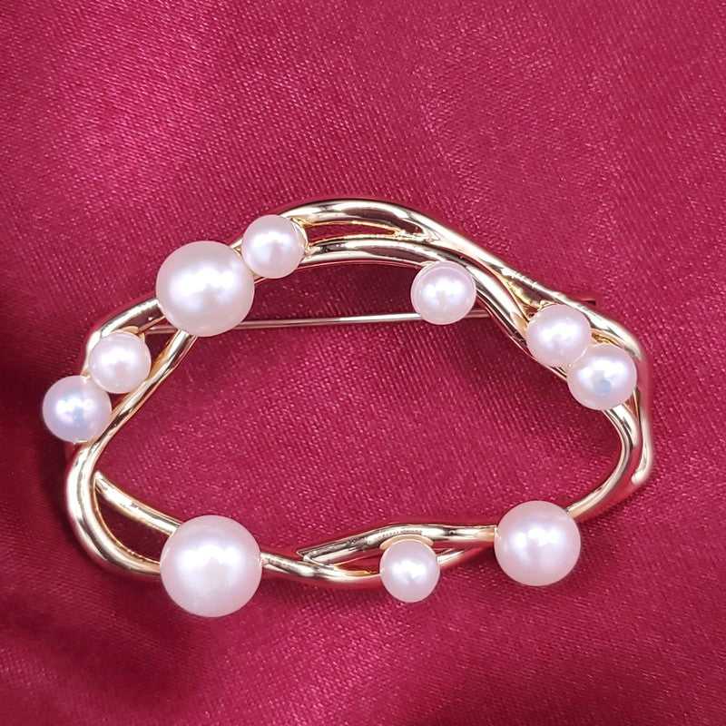 Refined Seashell Brooch in Gold finish, with pearl stone on a neutral background