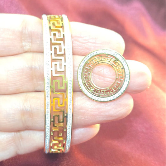 Gold and silver ring on a hand with a soft pink background