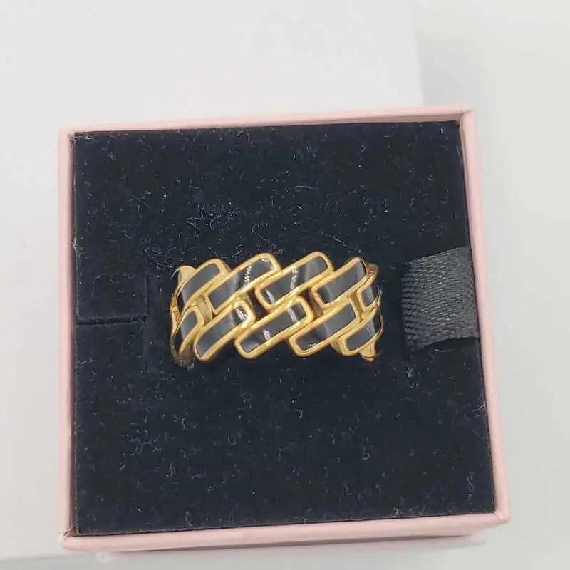 Sophisticated Enamel Ring in Gold finish on a neutral background