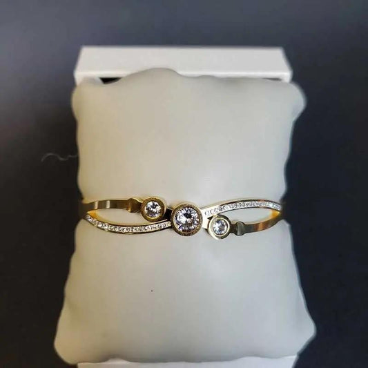 Sophisticated Shiny Bangle in Gold finish, with cubic zirconia stone on a neutral background