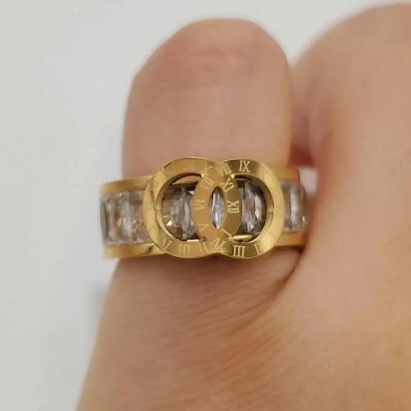 Timeless Ring in Gold finish, with cubic zirconia stone on stones and two interwoven gold rings with Roman numerals
