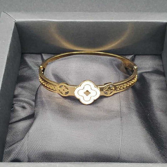 White Clover Bangle in Gold finish on a neutral background